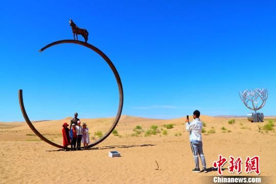 图为游客在沙漠雕塑公园游览留影 马爱彬 摄