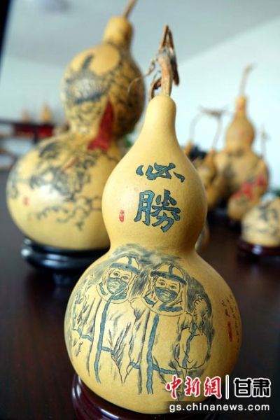 图为贺生强以微雕技艺在葫芦上雕刻战"疫"故事.