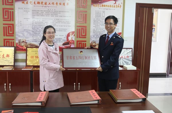 图为共青团庆阳市委副书记黄静为宁县税务局团支部颁发奖牌.